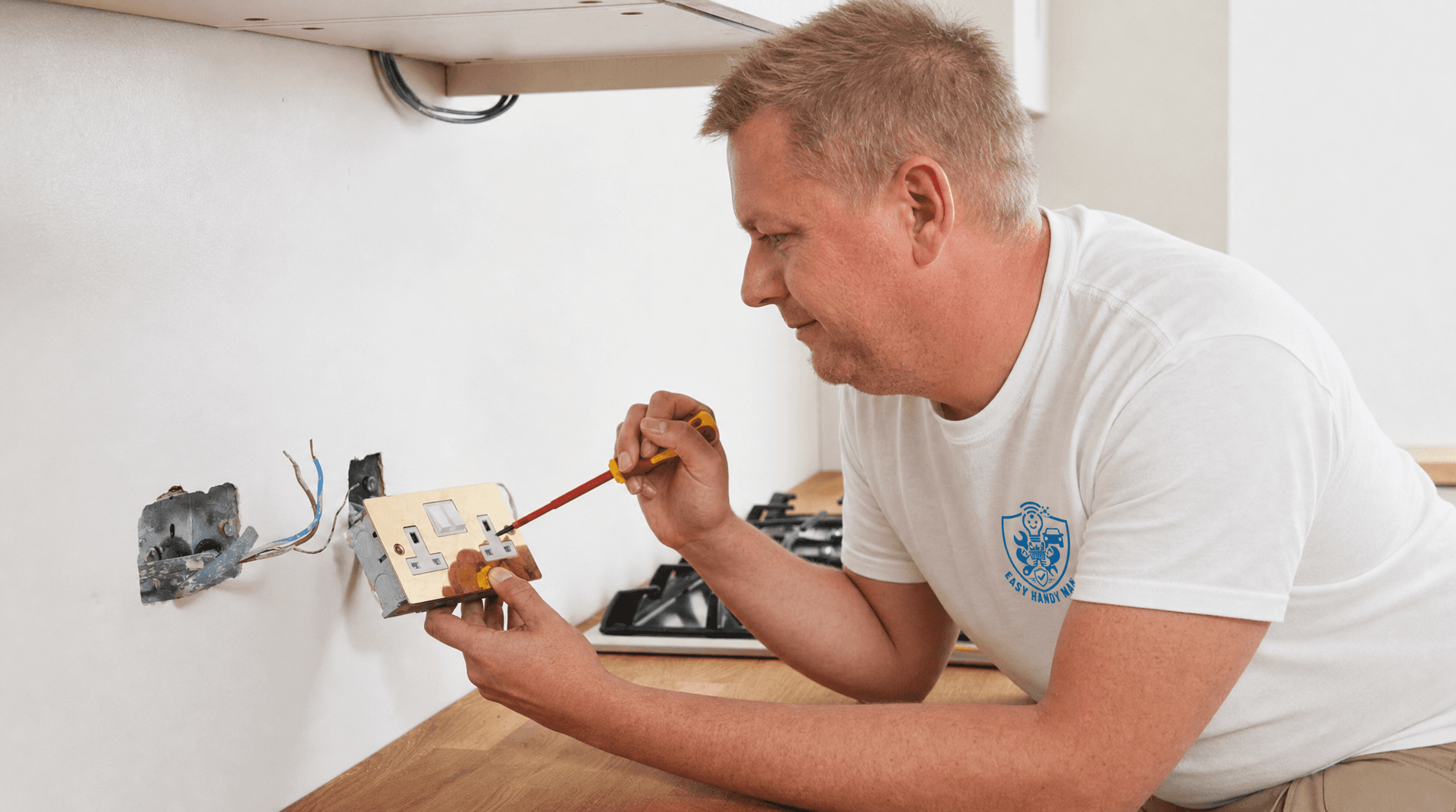 Handyman fitting a wall electrical socket with an insulated screwdriver